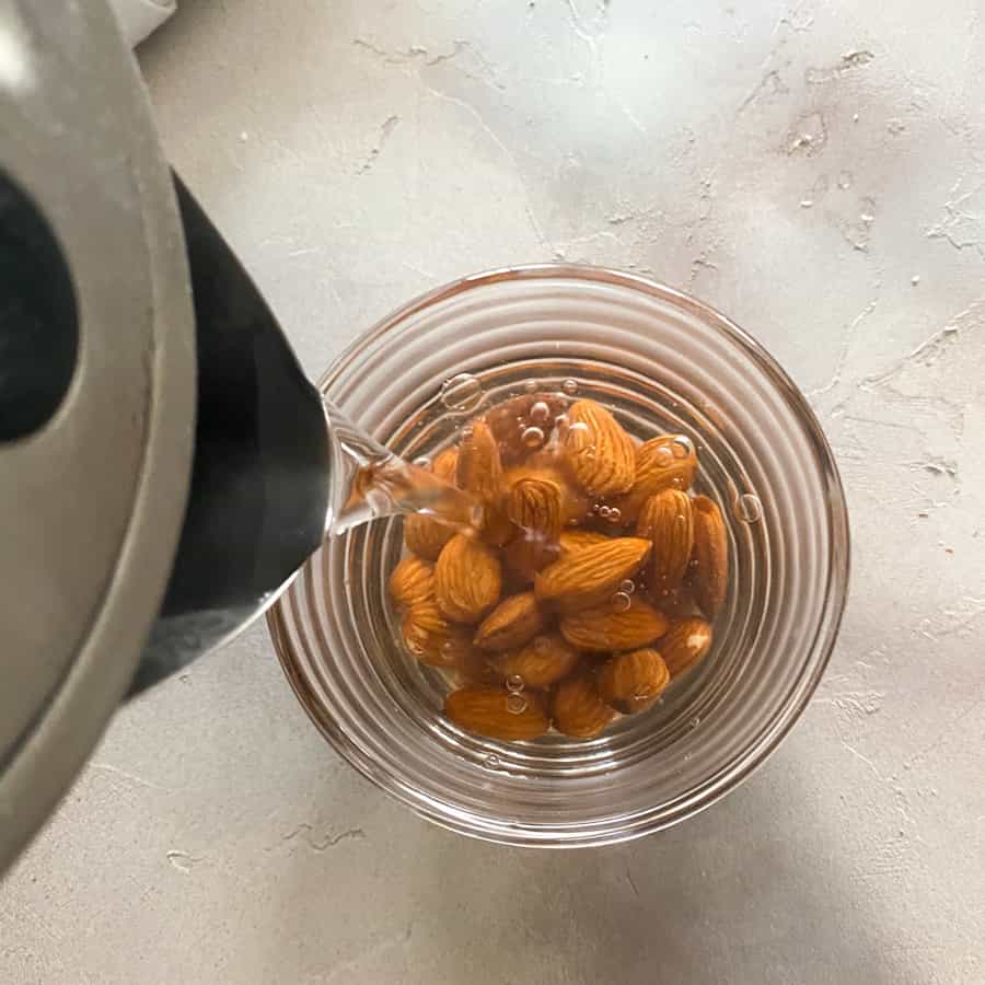 Pouring hot water over almonds to blanch them