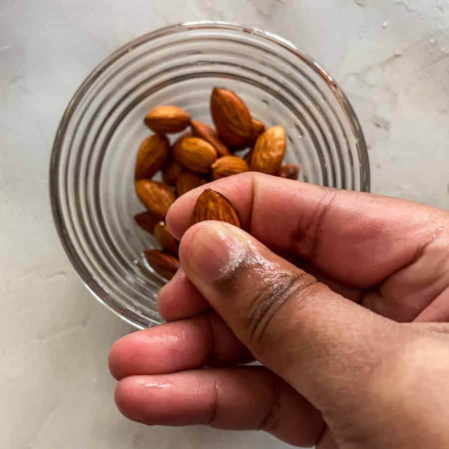 Using fingers to peel off almond skin