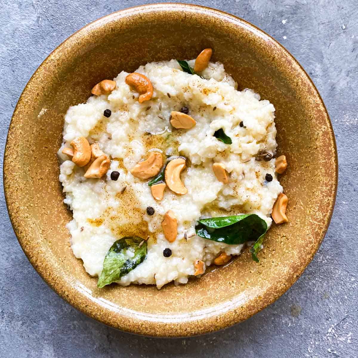 Pongal with toasted cashews in a small bowl