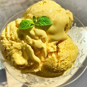 Kesar mango ice cream scoops with a mint garnish