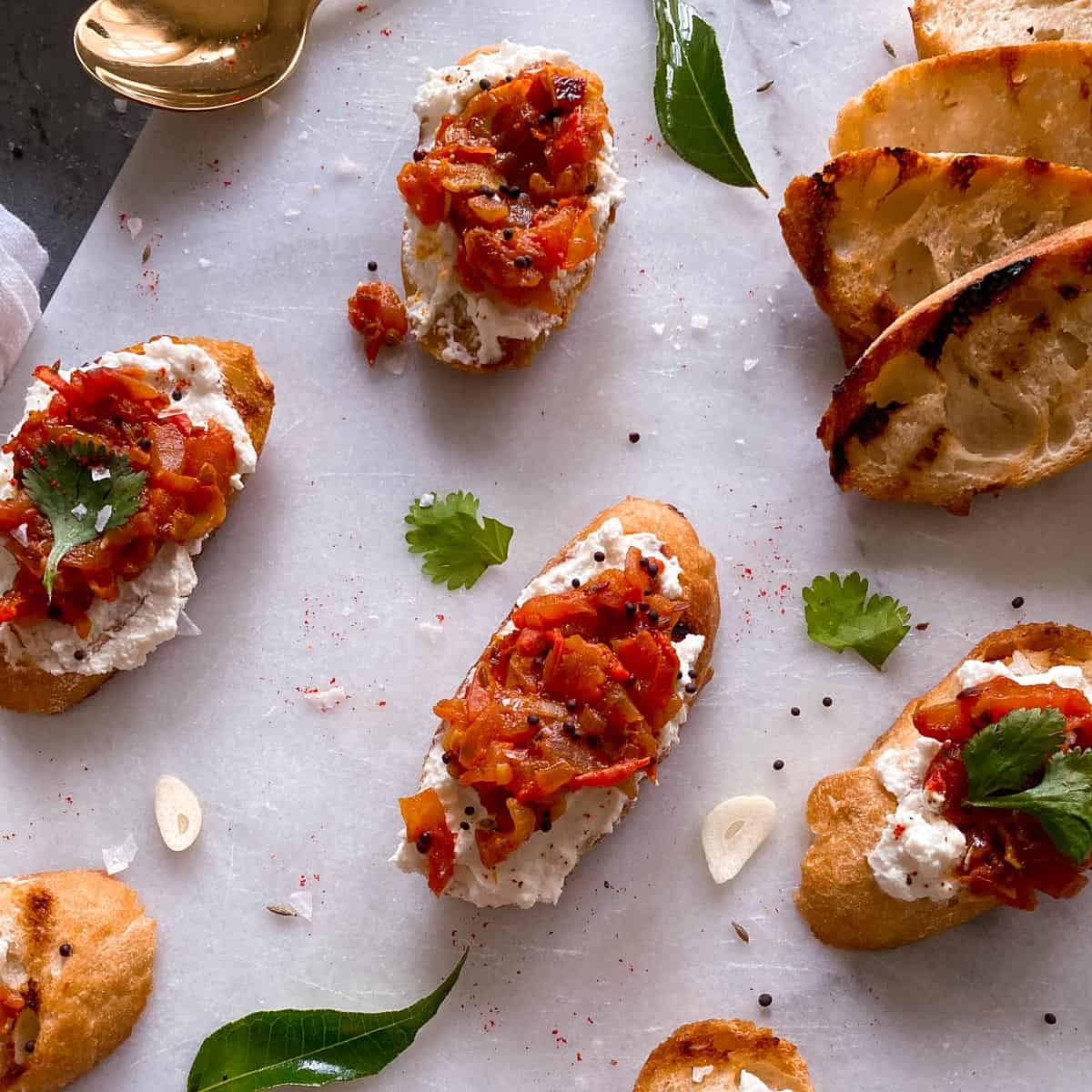 Slices of tomato chutney bruschetta on a serving board