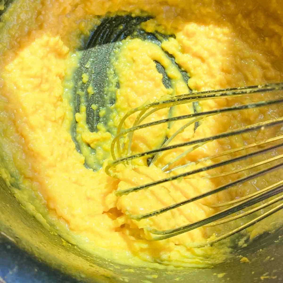 Moong dal is whisked with an egg beater to help emulsify fat and liquid