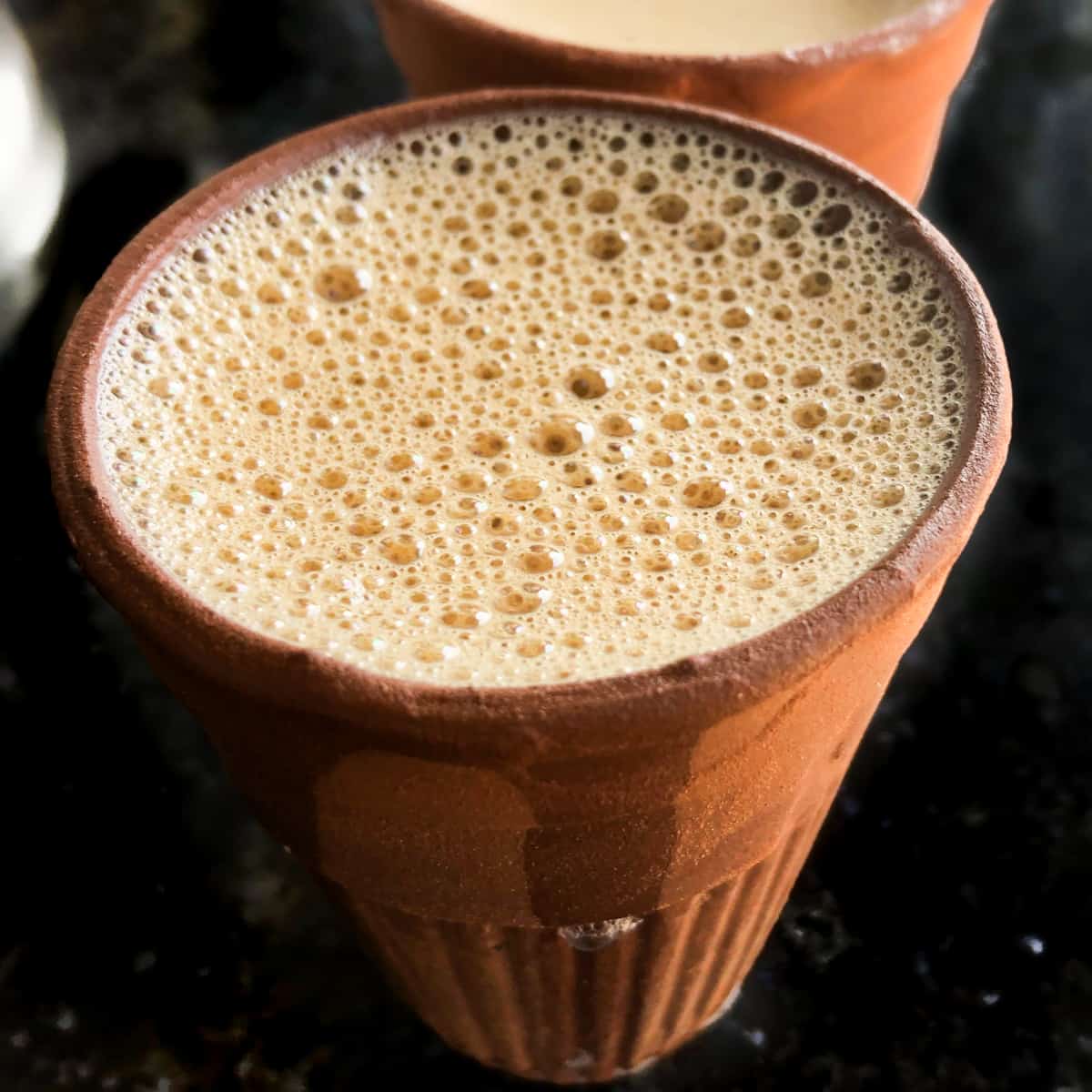 Hot, frothy, masala chai in an Indian clay cup.