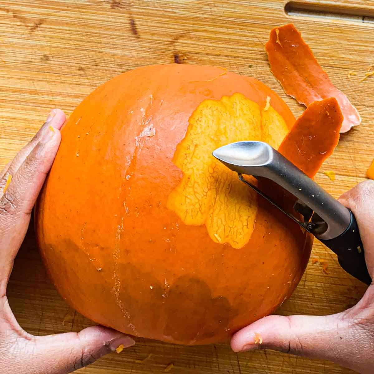 Removing pumpkin skin from pumpkin using vegetable peeler