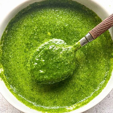 Cilantro Mint Chutney in a bowl with a spoon scooping some out