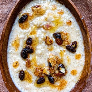 Pal Payasam or Indian rice pudding in a bowl with ghee and raisins and nuts