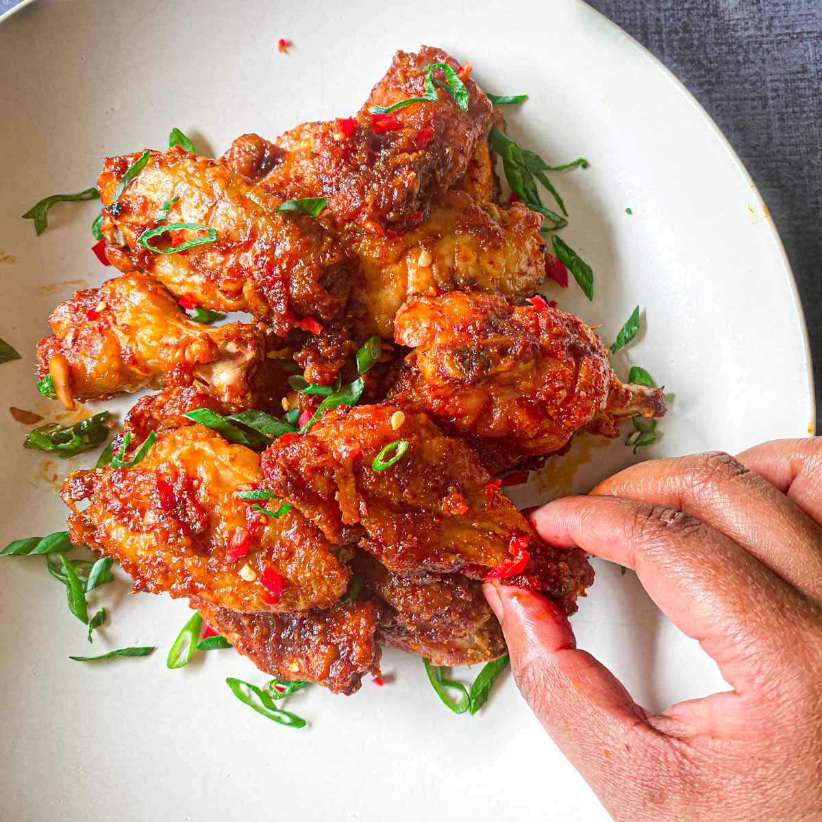 Chicken Manchurian Wings with hands picking them up