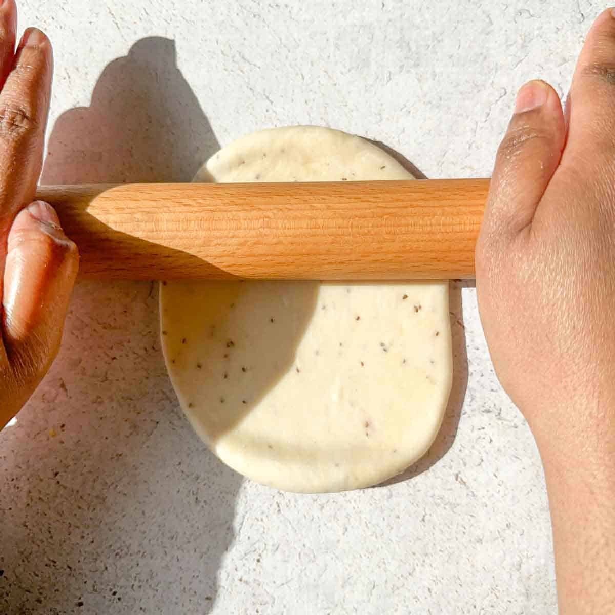 Samosa dough being rolled into a semi circle