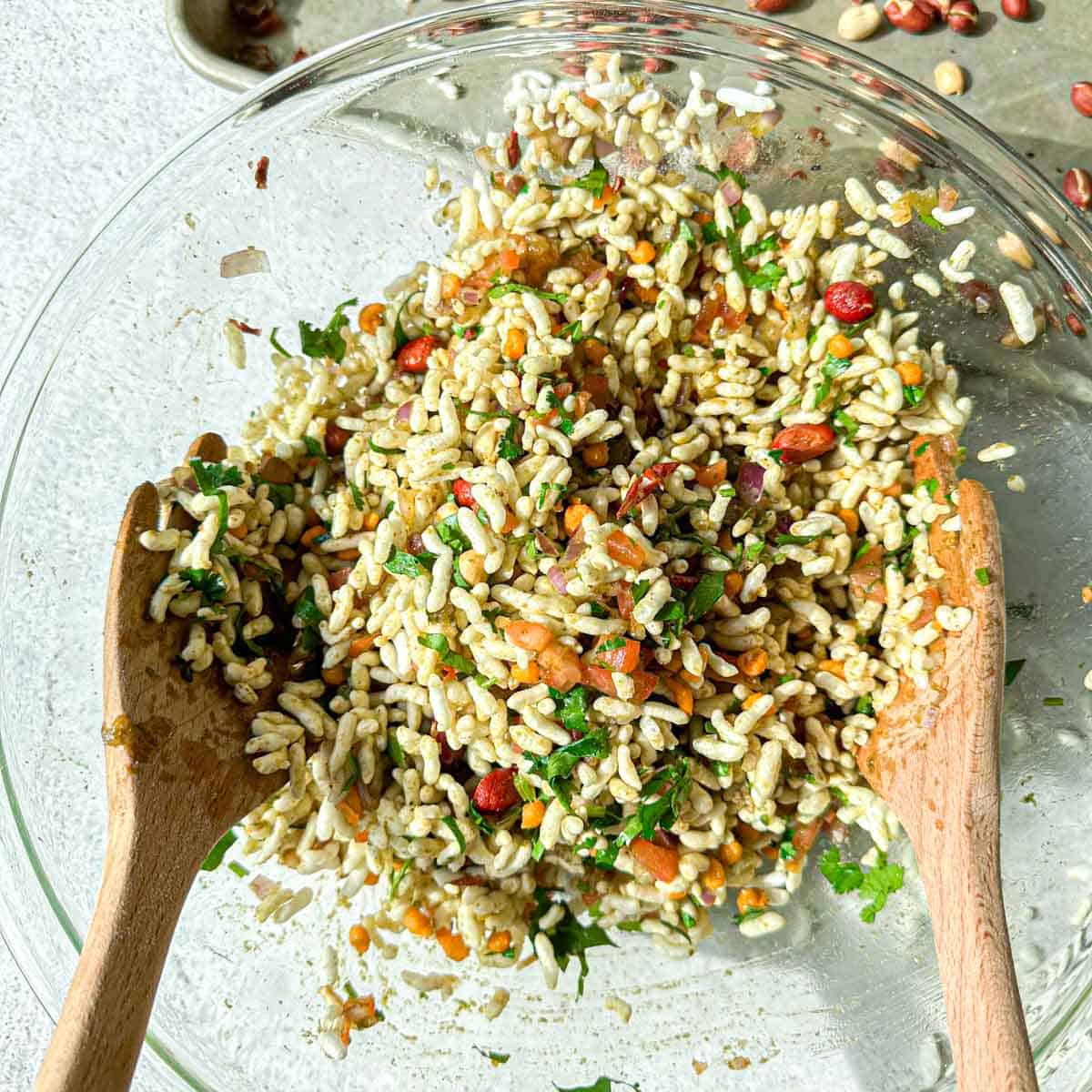 Bhel puri being tossed togther in a bowl