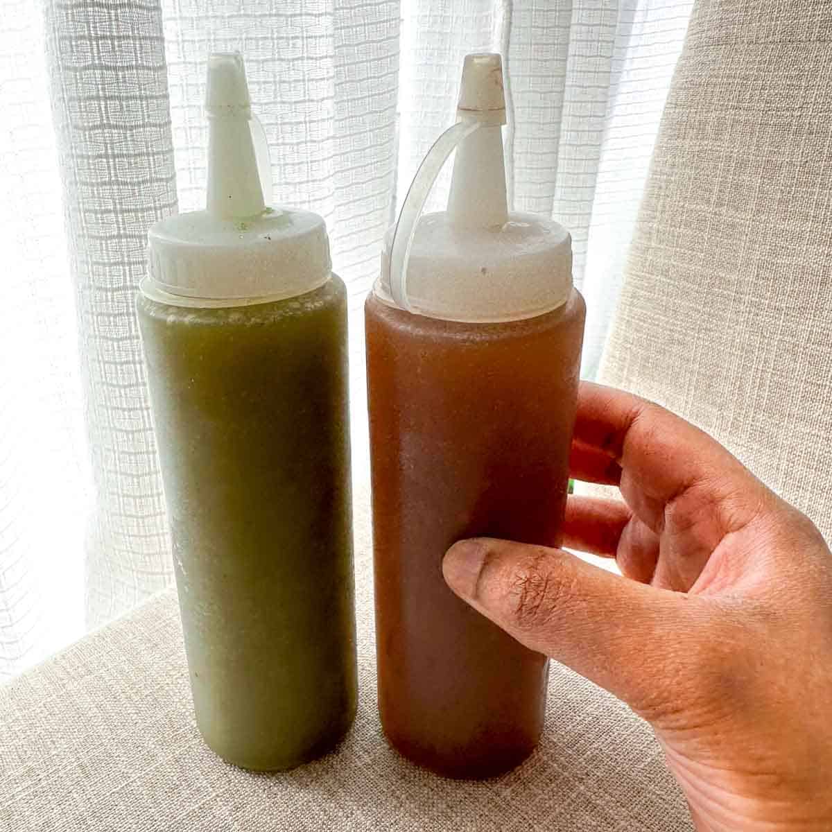 Two squeeze bottles filled with pani. Left bottle has spicy green pani and right bottle has sweet tamarind pani