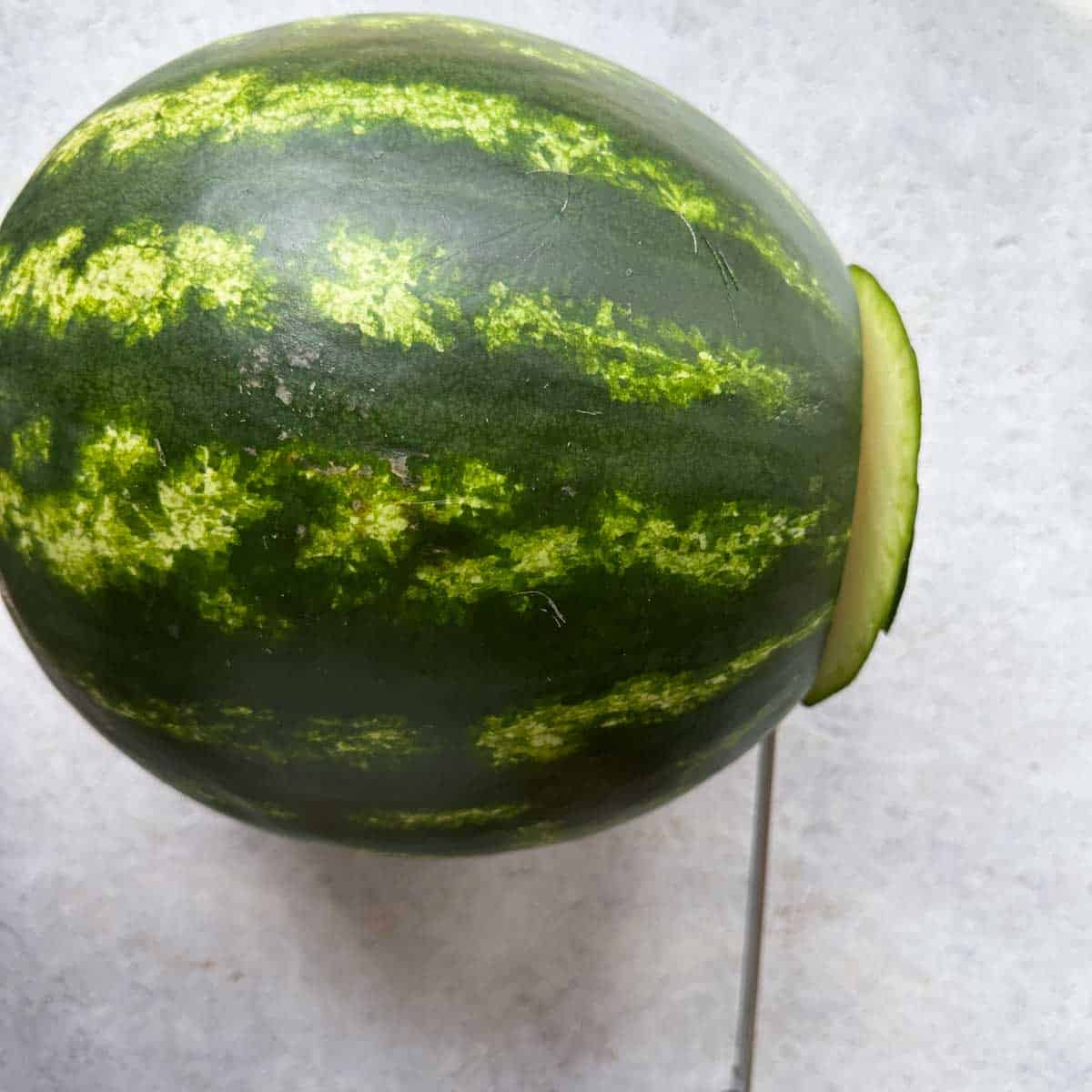 Cutting the bottom of the watermelon with a knife to make it flat
