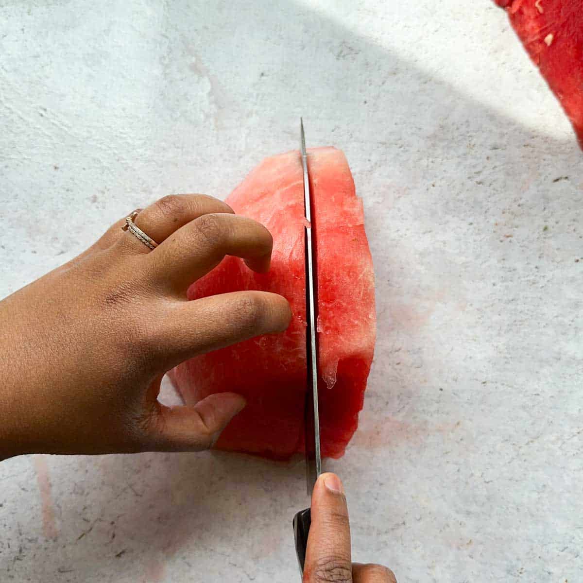 Cutting a quarter of a watermelon into 1 inch slabs