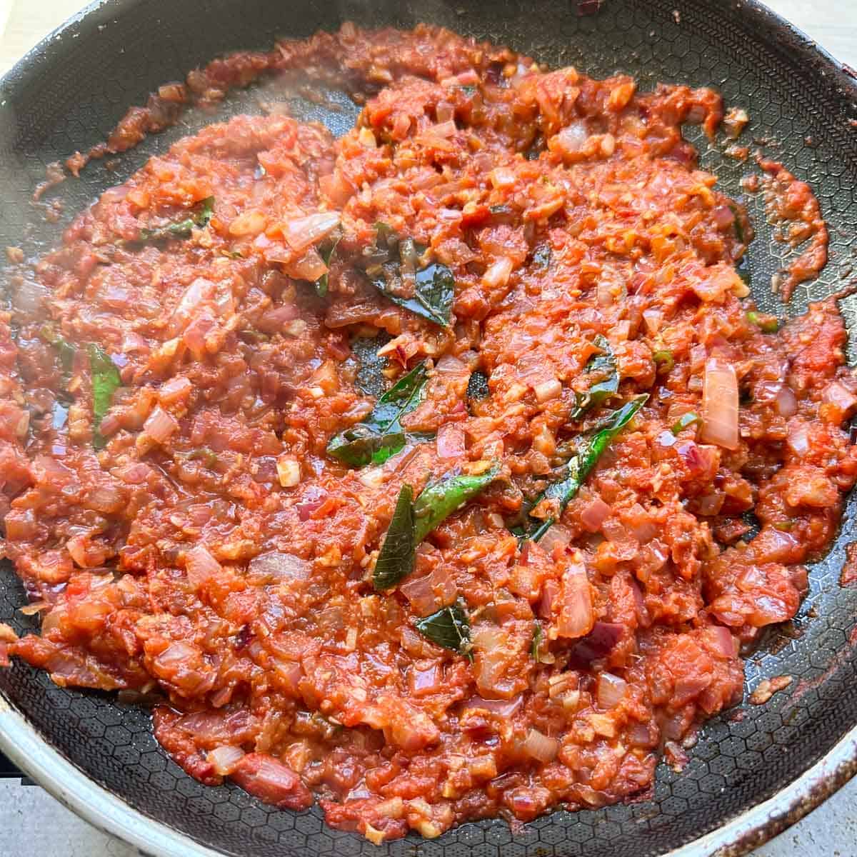Tomato Onion or vengayam thakkali chutney simmering and thickening in a pan