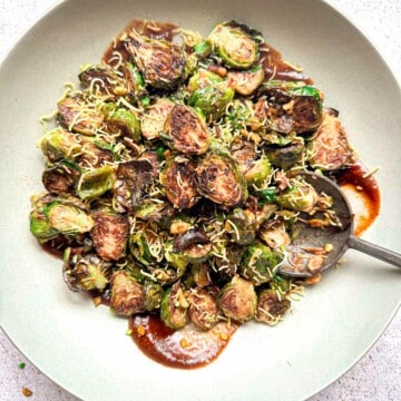 Indian roasted brussels sprouts with a tamarind date sauce in a while bowl