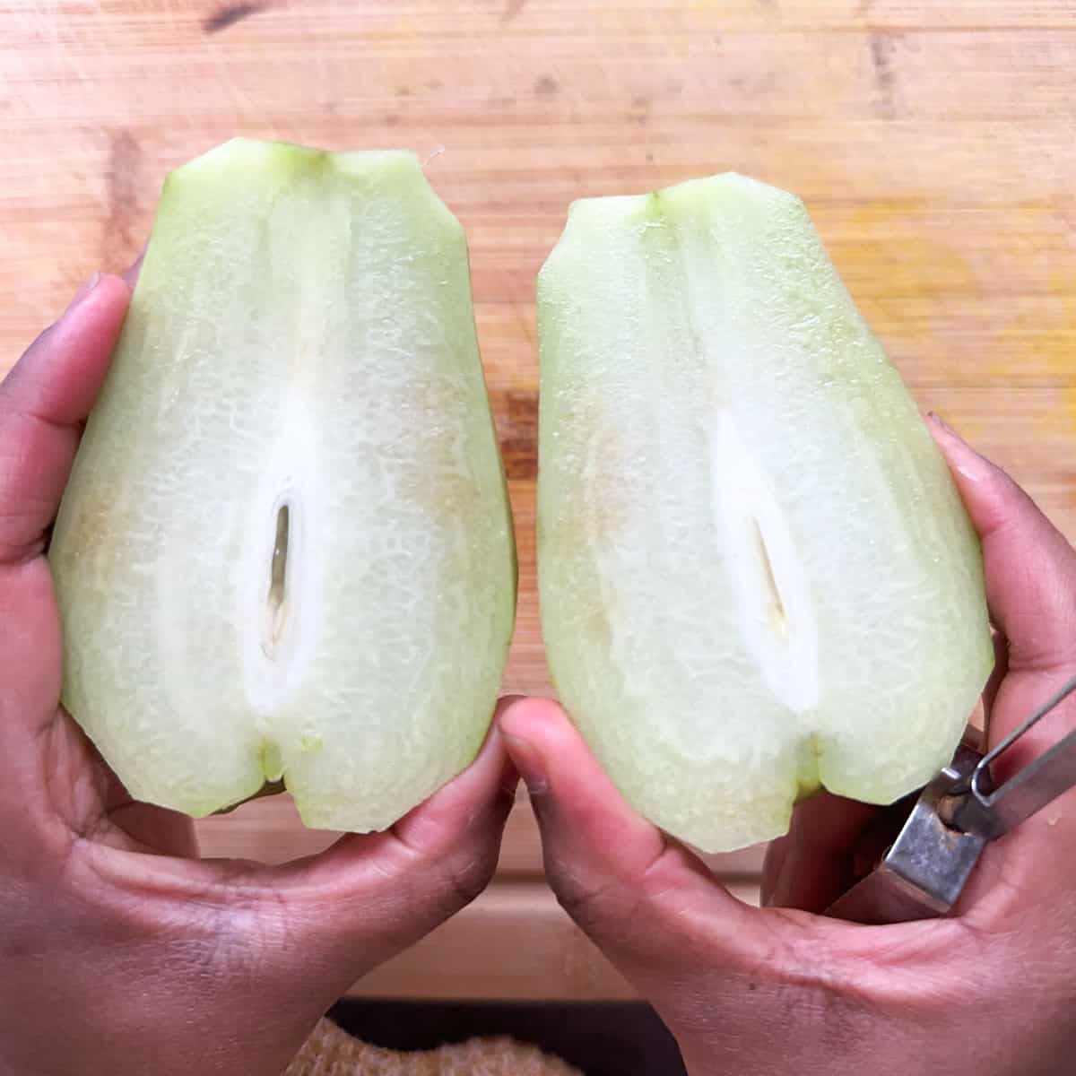 Chayote squash cut down vertically in the center.