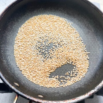 Picture of a pan with split urad dal that has been dry roasted and golden