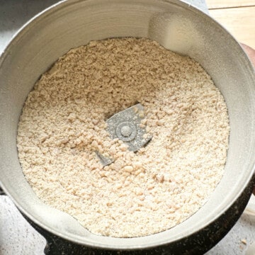 A spice grinder with coarsely ground urad dal and chana dal for milagai podi.