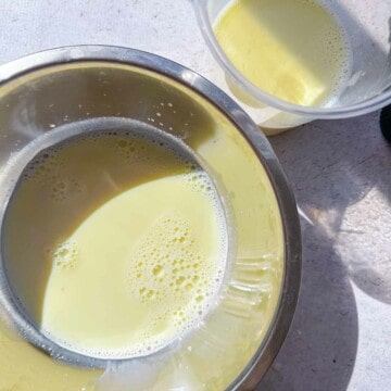 Two bowls with saffron cardamom milk.