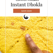 A finger pointing to red spots in the cooked dhokla. These spots indicate pockets of baking soda build up in the dhokla.