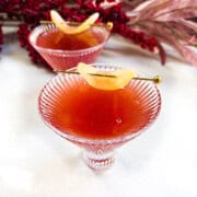 Two glasses of chaat spiced pomegranate mocktail with a candied ginger garnish.