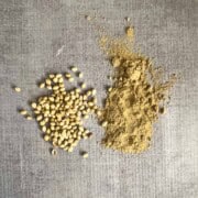 Whole coriander seeds next to ground coriander powder
