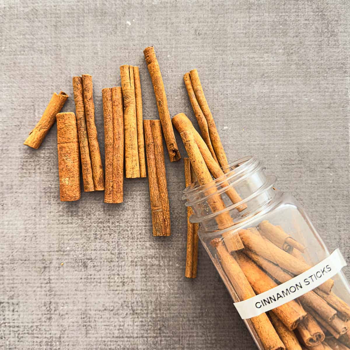 Cinnamon sticks poured out of a spice container.