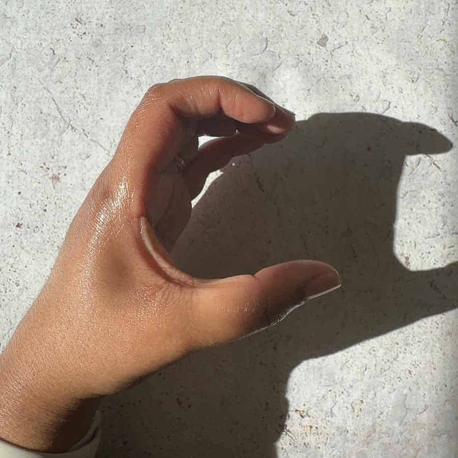 Hand positioned in a c shape to hold a samosa.